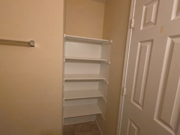a view of walk in closet with empty racks