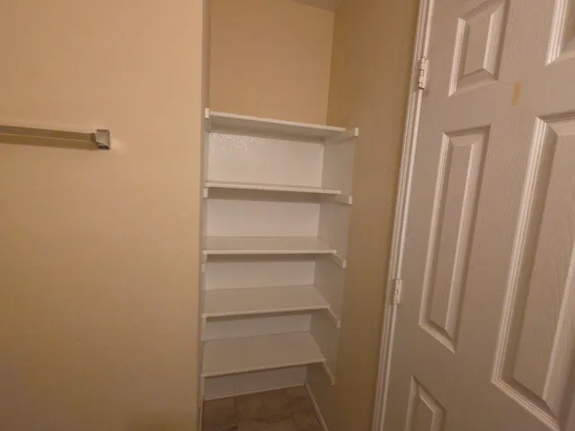 a view of walk in closet with empty racks