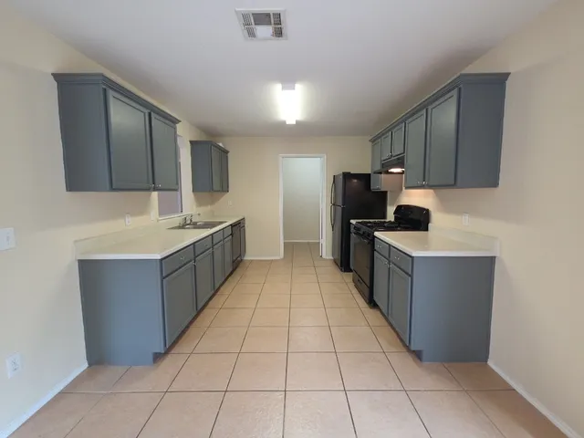 a large kitchen with stainless steel appliances lots of counter top space