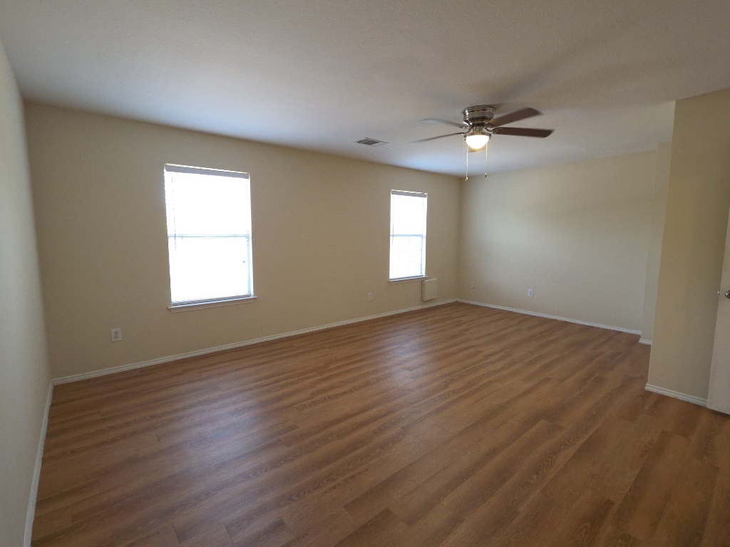 204 Ruby Lake Drive Kyle, TX 78640 - Photo 10 of 22 Spare room featuring dark wood-style floors and a ceiling fan
