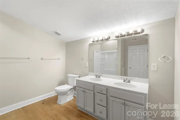 a bathroom with a double vanity sink toilet and a mirror