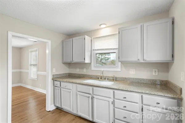 a kitchen with granite countertop white cabinets and a sink