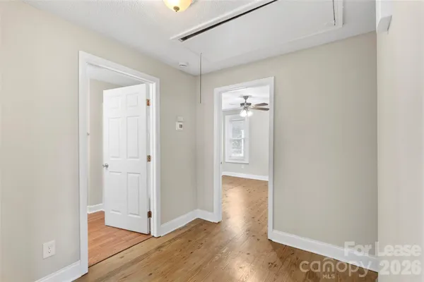 a view of a hallway with wooden floor