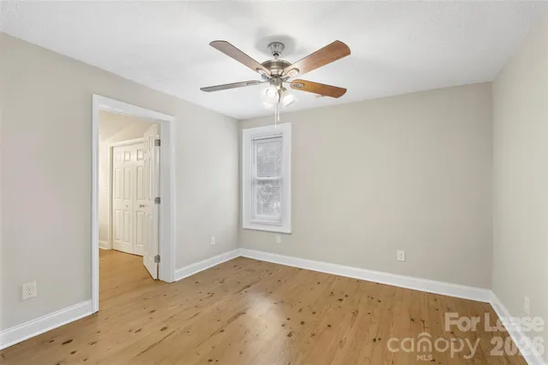 a view of a room with wooden floor and white walls