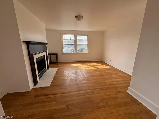 a view of an empty room with a fireplace and a window