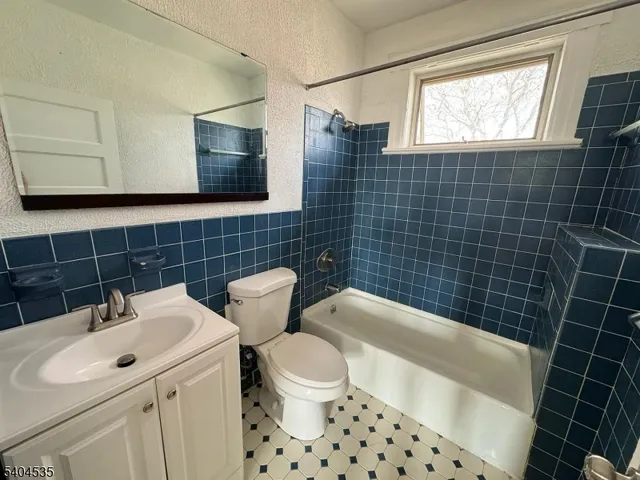 a bathroom with a sink a toilet a mirror and shower