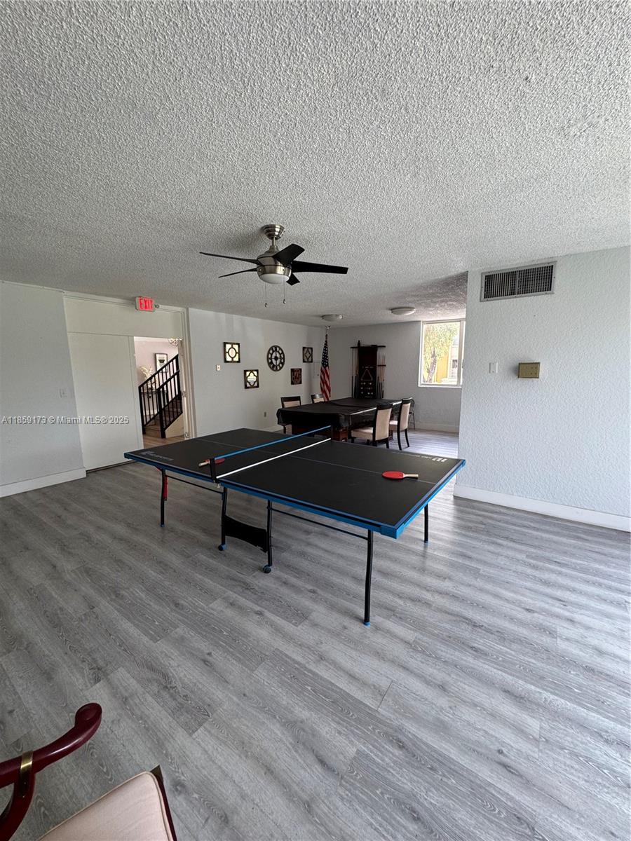 6841 Southwest 147th Avenue, Unit 1H Miami, FL 33193 - Photo 24 of 26 a living room with furniture and a wooden floor