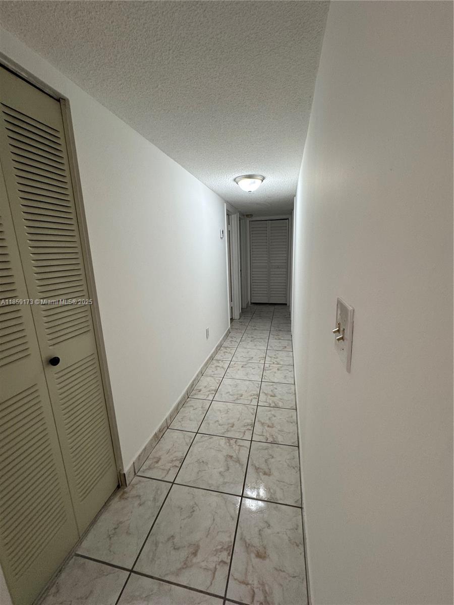 6841 Southwest 147th Avenue, Unit 1H Miami, FL 33193 - Photo 10 of 26 a view of hallway with an empty space and a window