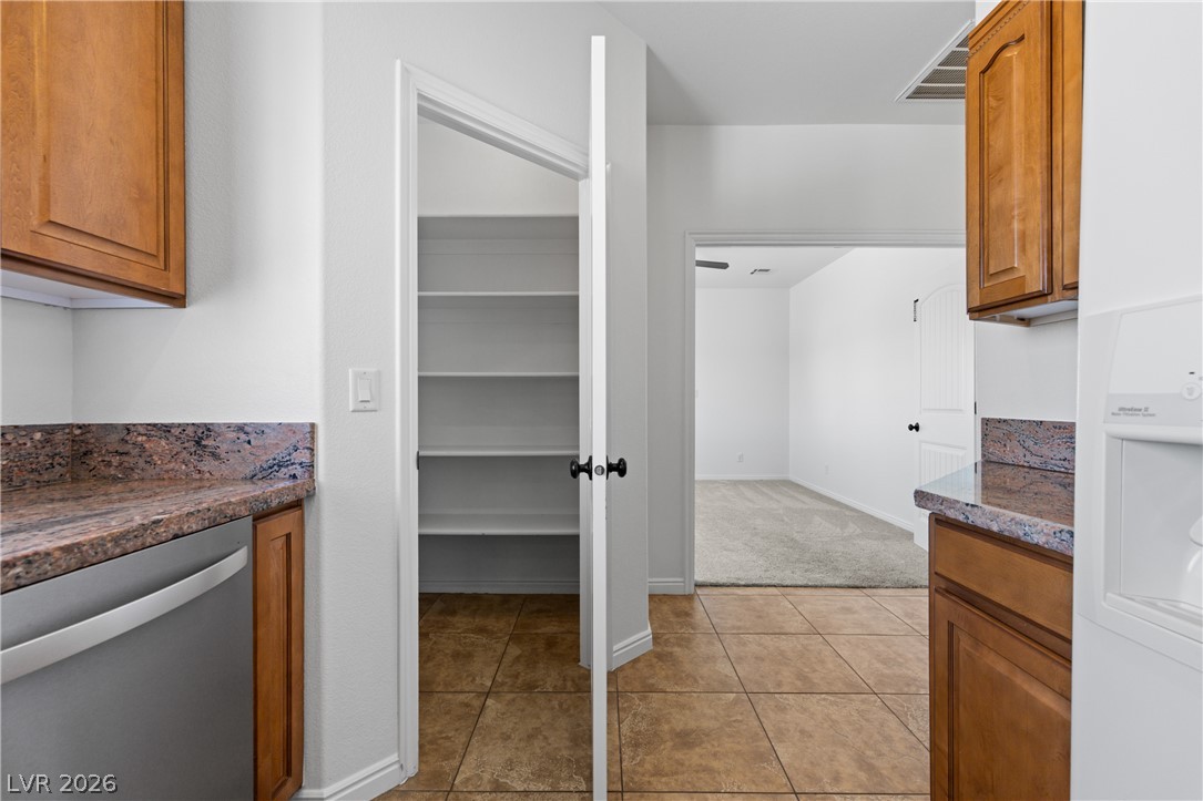 575 Gann Avenue Logandale, NV 89021 - Photo 22 of 75 A well-appointed kitchen pantry offers ample storage within reach of granite countertops and wood cabinetry.