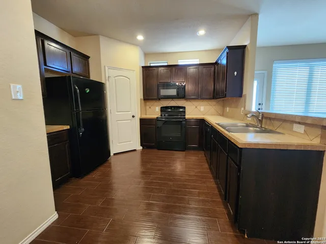 a kitchen with stainless steel appliances granite countertop a refrigerator a sink and a stove