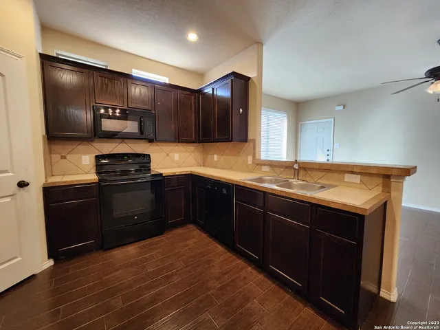 a kitchen with stainless steel appliances granite countertop a refrigerator and a sink