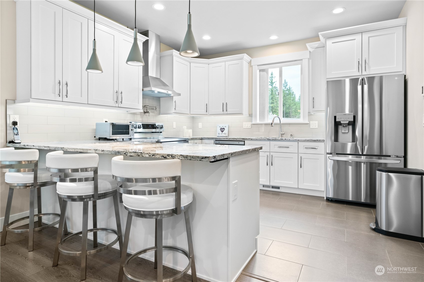 8487 Cimarron Way Maple Falls, WA 98266 - Photo 17 of 39 a kitchen with stainless steel appliances granite countertop a sink a stove a refrigerator cabinets and chairs
