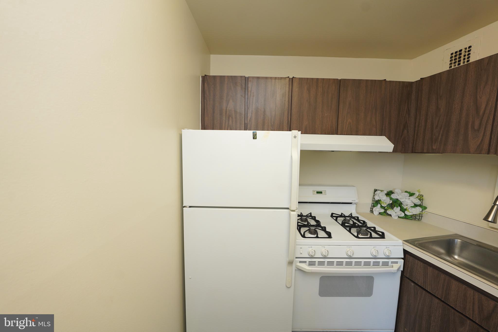 1111 University Boulevard West, Unit 1001A Silver Spring, MD 20902 - Photo 18 of 27 a white refrigerator freezer sitting inside of a kitchen
