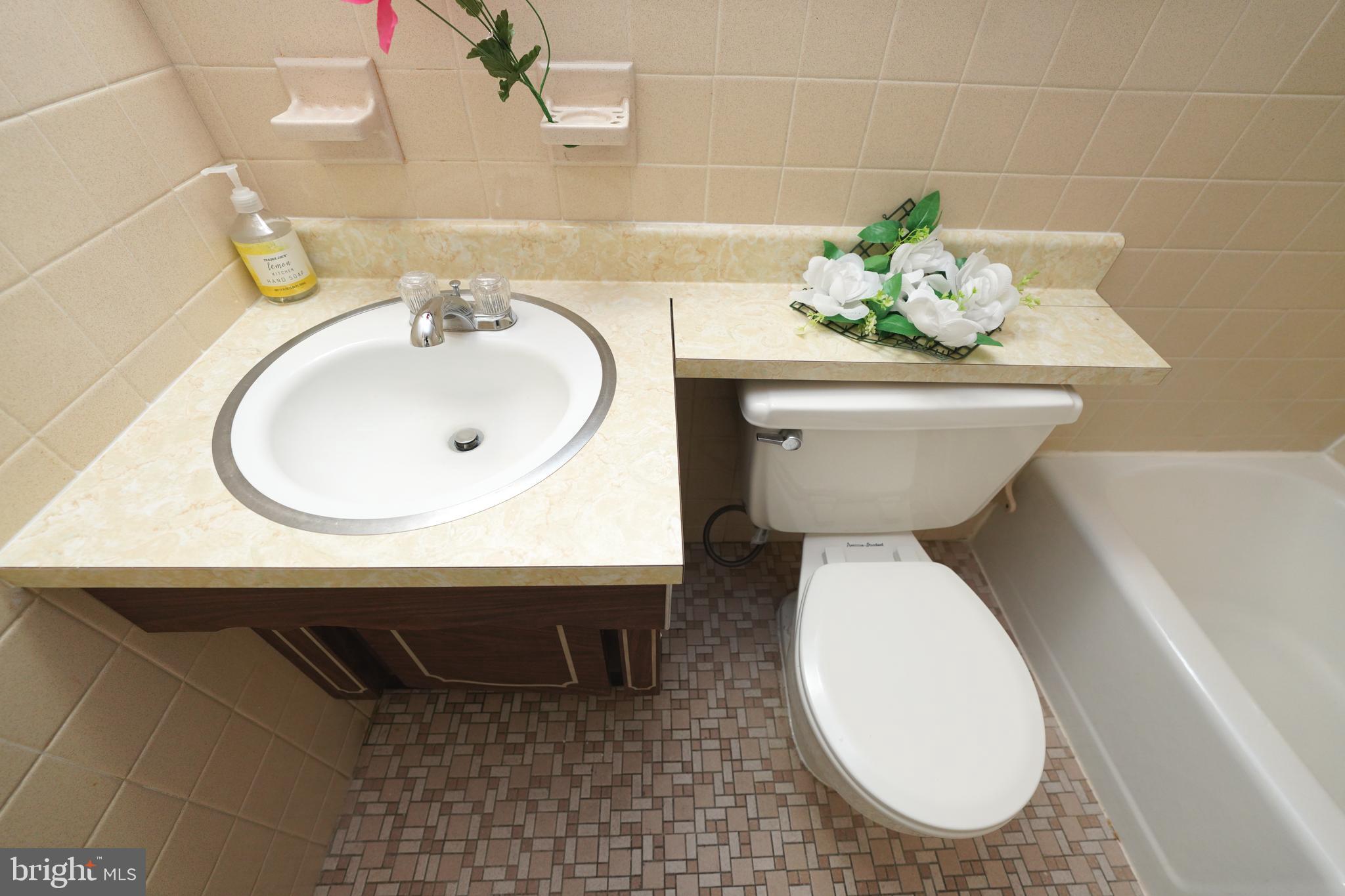 1111 University Boulevard West, Unit 1001A Silver Spring, MD 20902 - Photo 21 of 27 a bathroom with a sink a toilet and a mirror