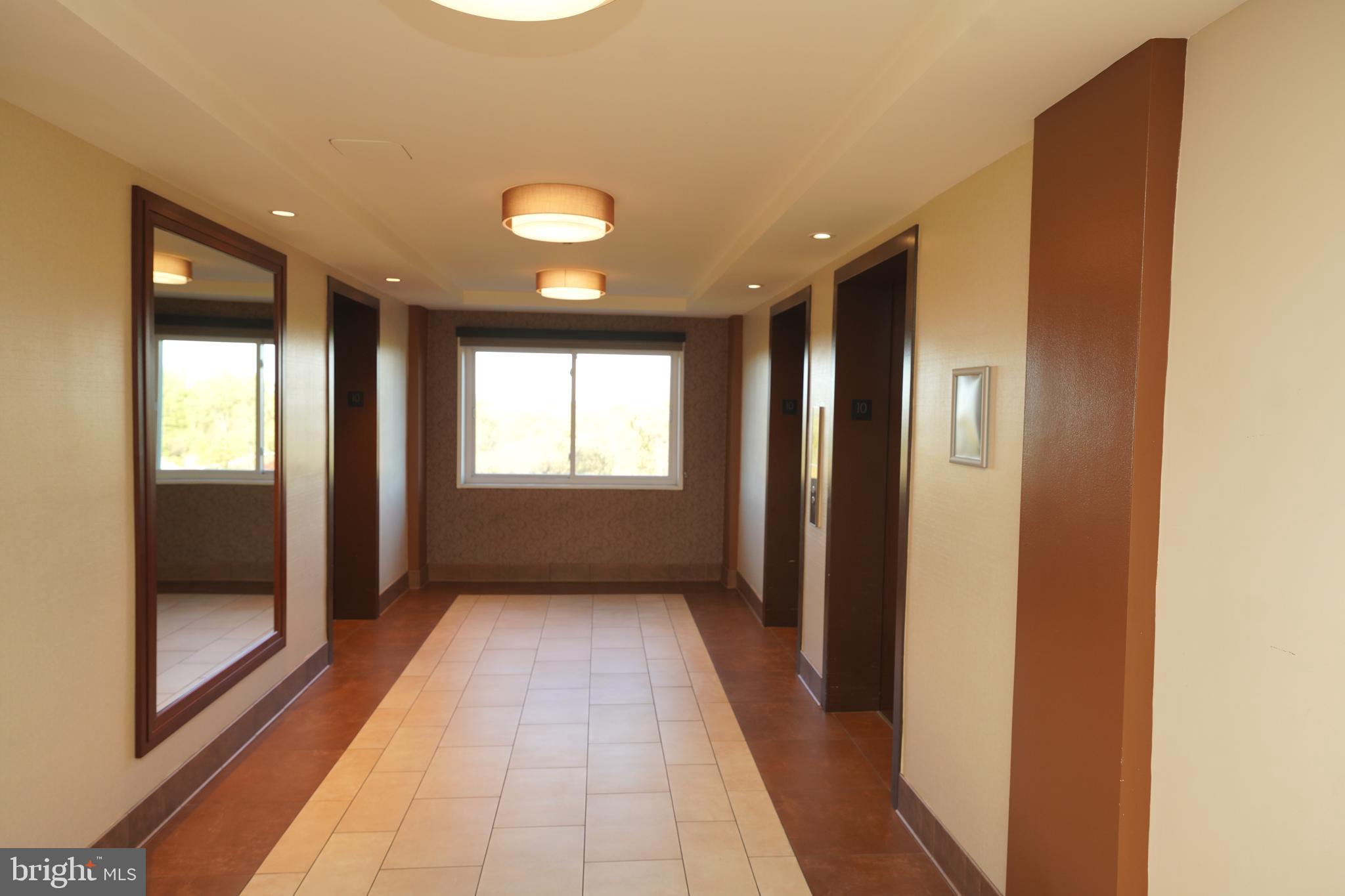 1111 University Boulevard West, Unit 1001A Silver Spring, MD 20902 - Photo 6 of 27 a view of hallway with a large window and front door