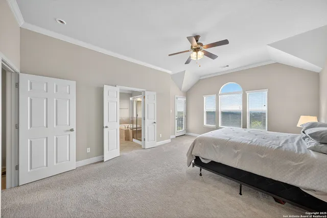a bedroom with a large bed chandelier and a window