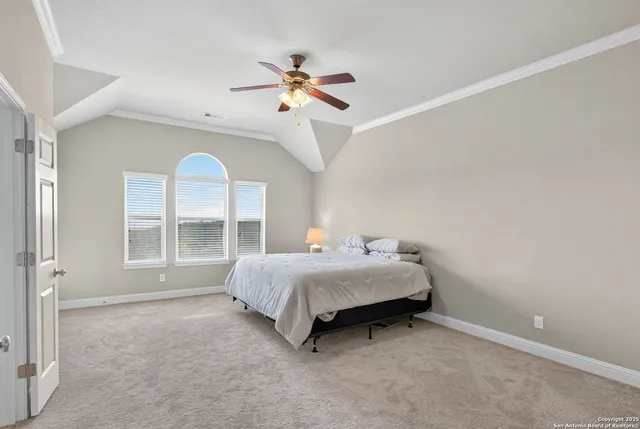 a spacious bedroom with a bed and a chandelier
