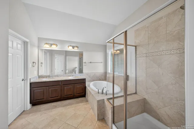 a bathroom with a tub sink and mirror