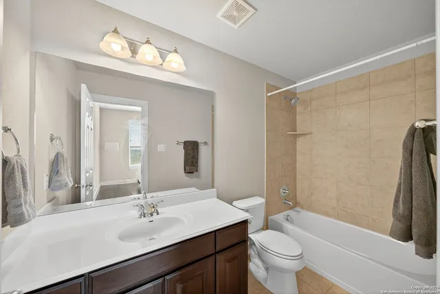 a bathroom with a sink a toilet a mirror and shower