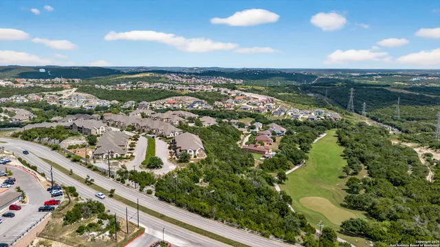 an aerial view of residential houses with outdoor space and trees