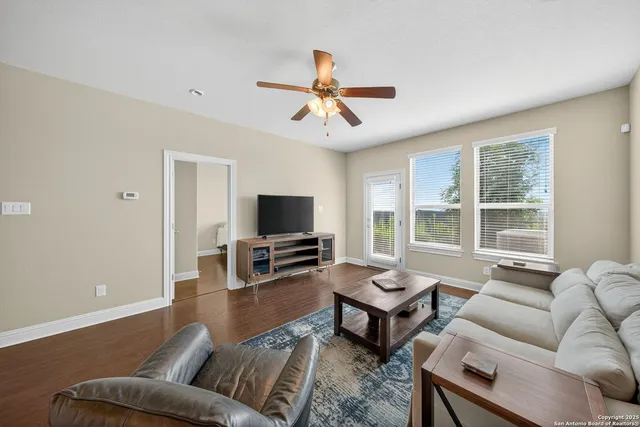 a living room with furniture a flat screen tv and a large window
