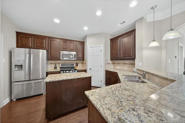 a kitchen with stainless steel appliances granite countertop a refrigerator stove microwave and sink