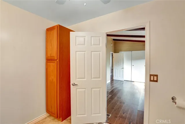 an empty room with wooden floor and a bathroom