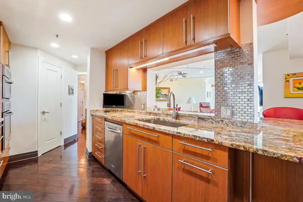 a kitchen with stainless steel appliances granite countertop a sink and wooden cabinets