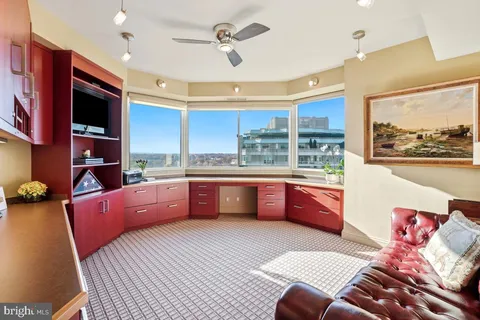 a large kitchen with stainless steel appliances kitchen island granite countertop a couch and a view of living room