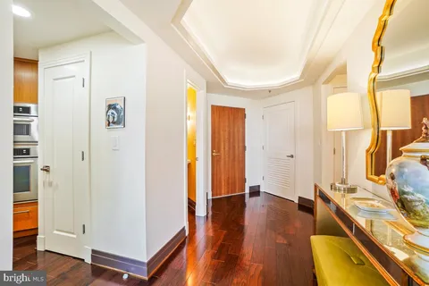 a view of a hallway with wooden floor and bathroom