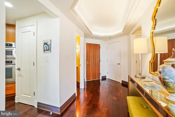 a view of a hallway with wooden floor and bathroom
