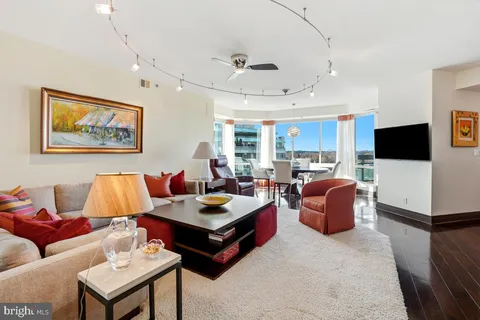 a living room with furniture kitchen view and a flat screen tv