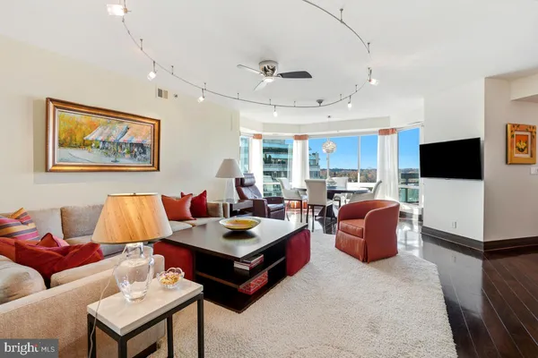 a living room with furniture kitchen view and a flat screen tv