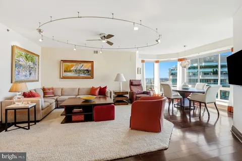 a living room with furniture kitchen view and a large window