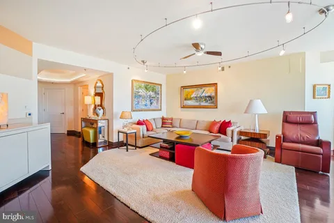 a living room with furniture kitchen view and a large window