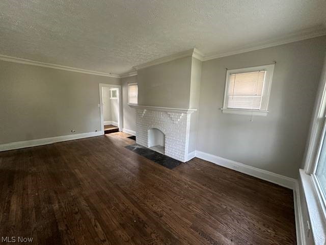 1752 South Taylor Road Cleveland, OH 44118 - Photo 2 of 14 Unfurnished living room with dark hardwood / wood-style flooring, a textured ceiling, a fireplace, and plenty of natural light