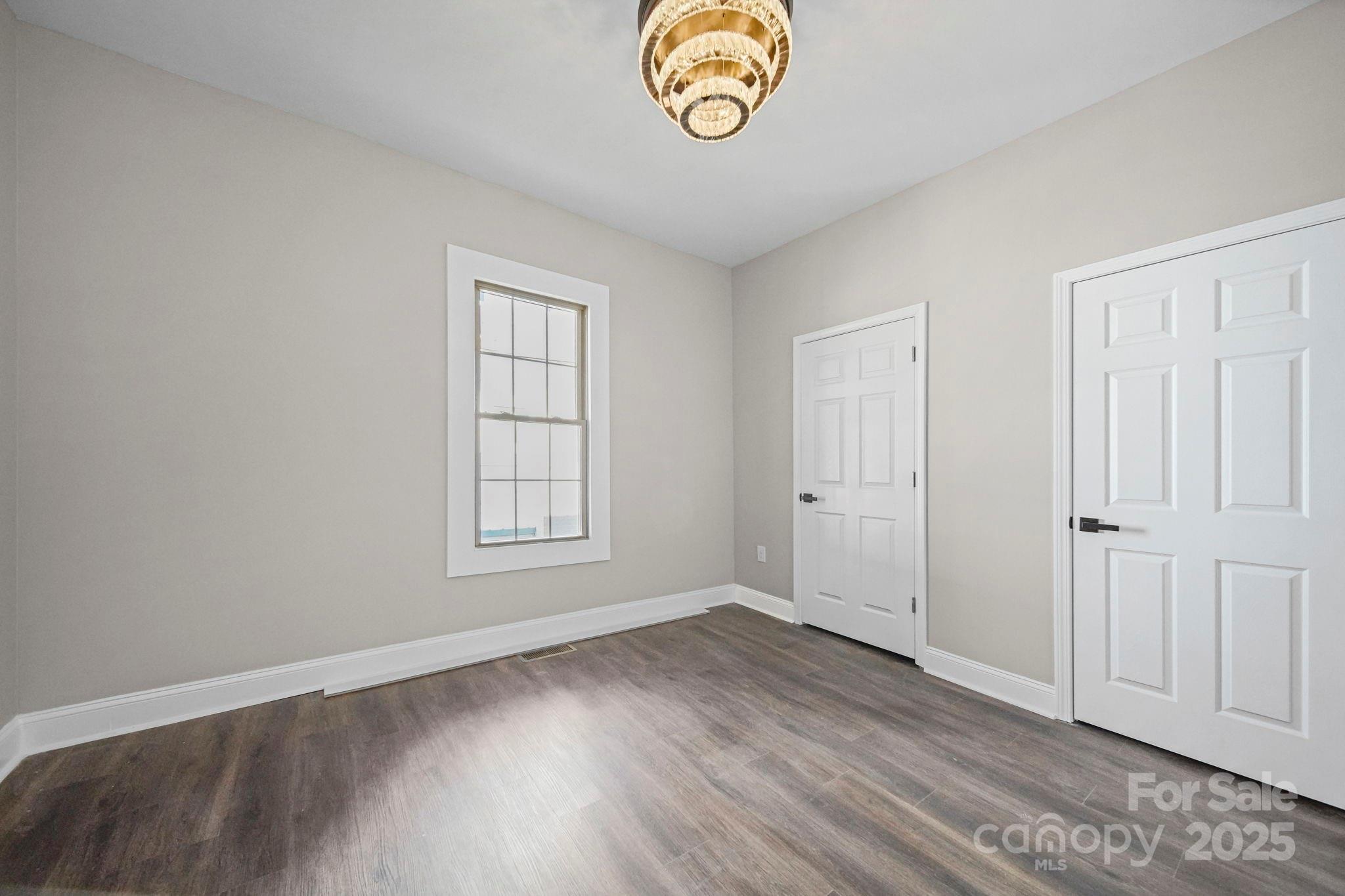 113 7th Street Spencer, NC 28159 - Photo 13 of 44 an empty room with wooden floor and a window