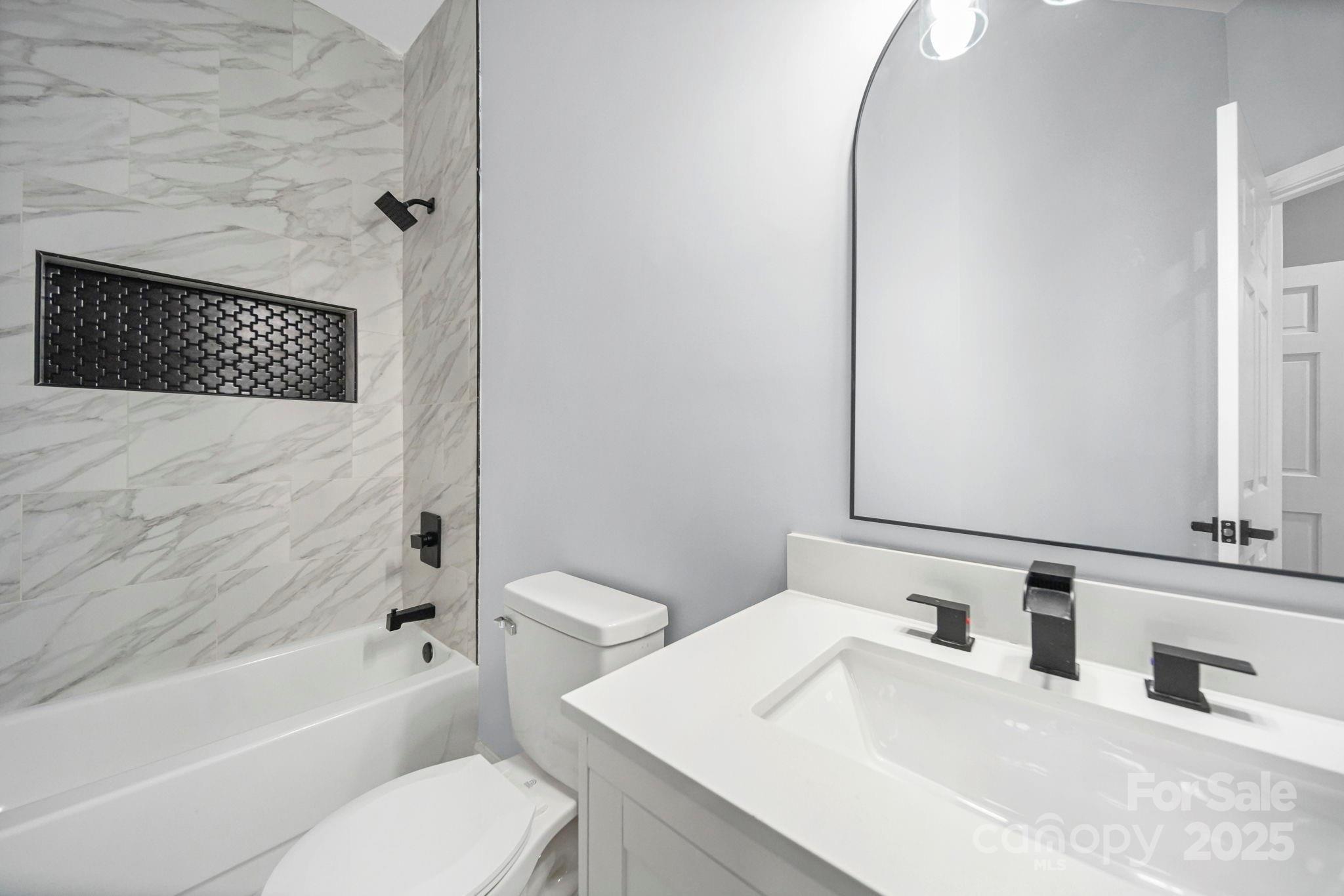 113 7th Street Spencer, NC 28159 - Photo 22 of 44 a bathroom with a sink a toilet and a bathtub