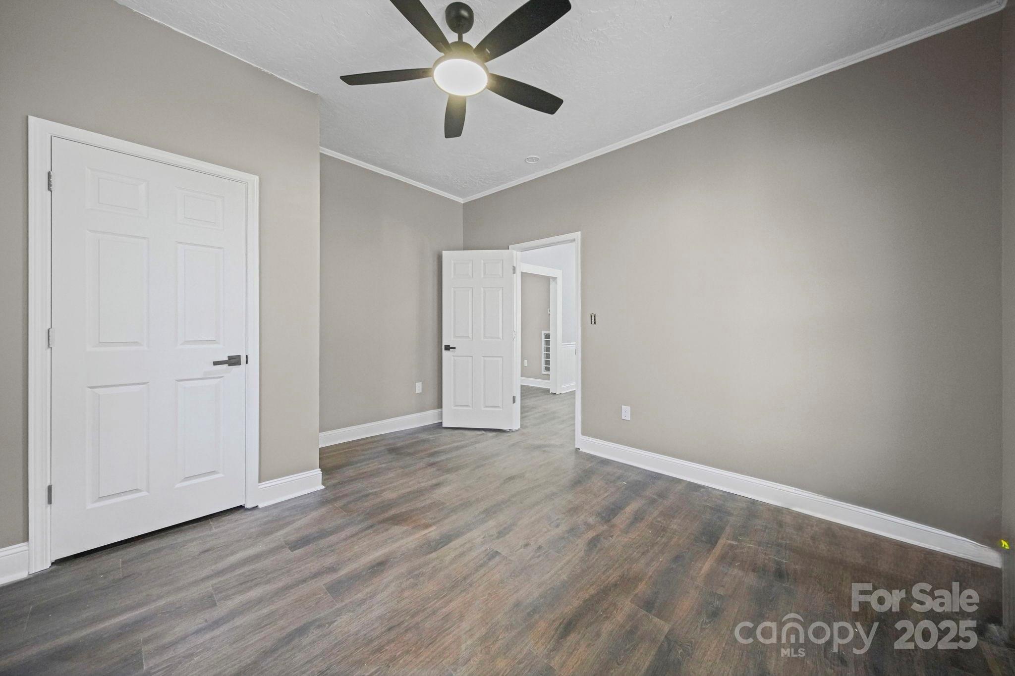 113 7th Street Spencer, NC 28159 - Photo 23 of 44 an empty room with wooden floor and windows