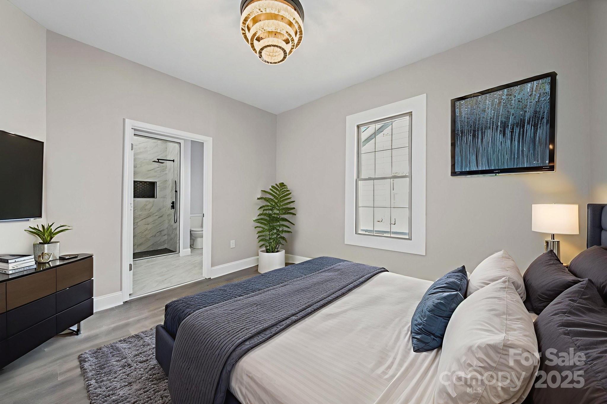 113 7th Street Spencer, NC 28159 - Photo 25 of 44 a bedroom with a bed and a chandelier