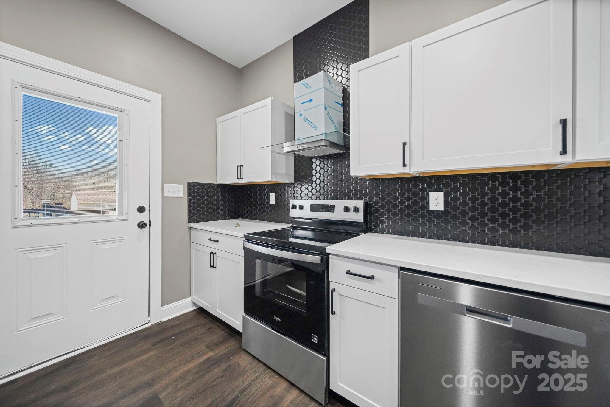 113 7th Street Spencer, NC 28159 - Photo 30 of 44 a kitchen with stainless steel appliances white cabinets and a stove top oven
