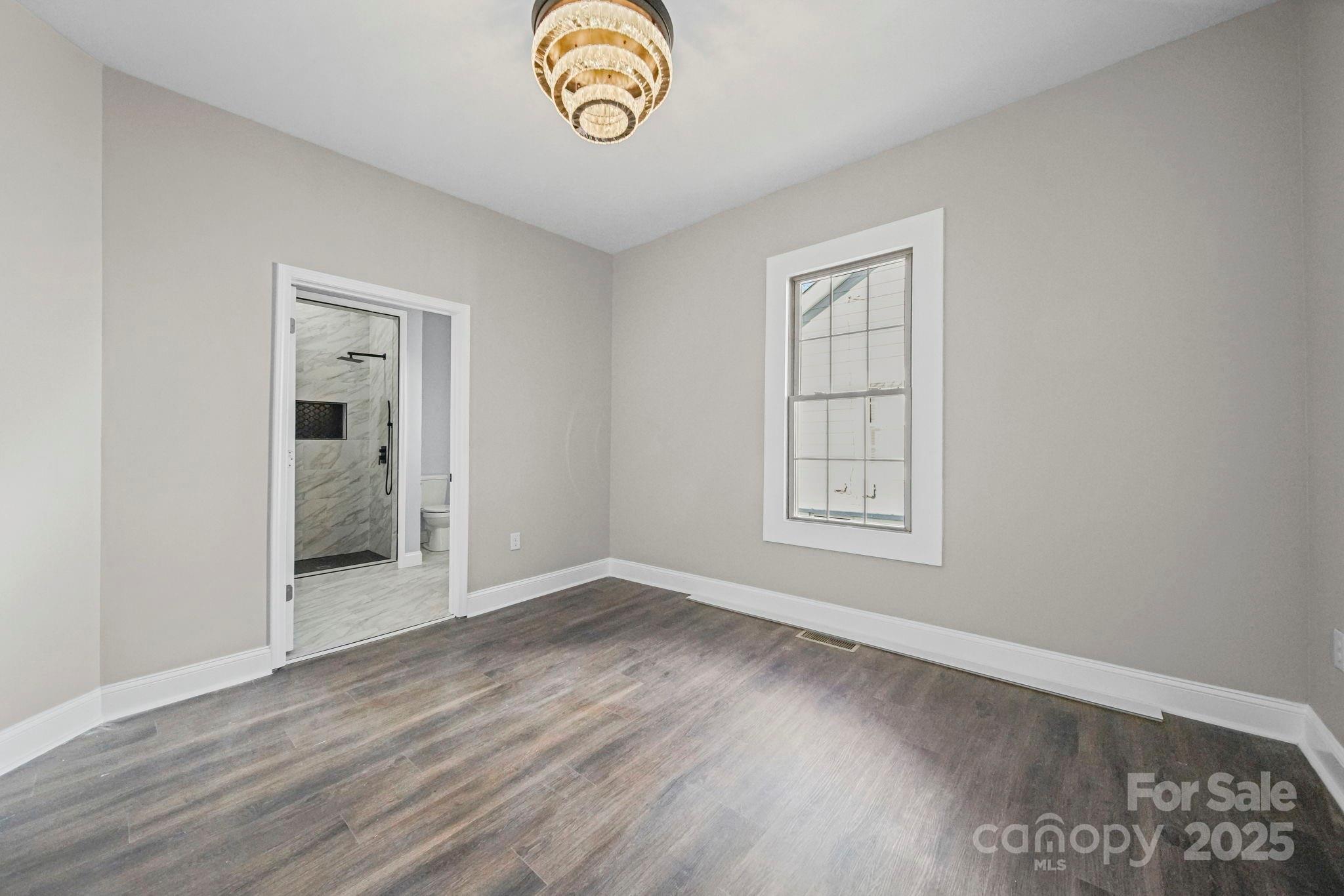 113 7th Street Spencer, NC 28159 - Photo 9 of 44 an empty room with wooden floor and windows