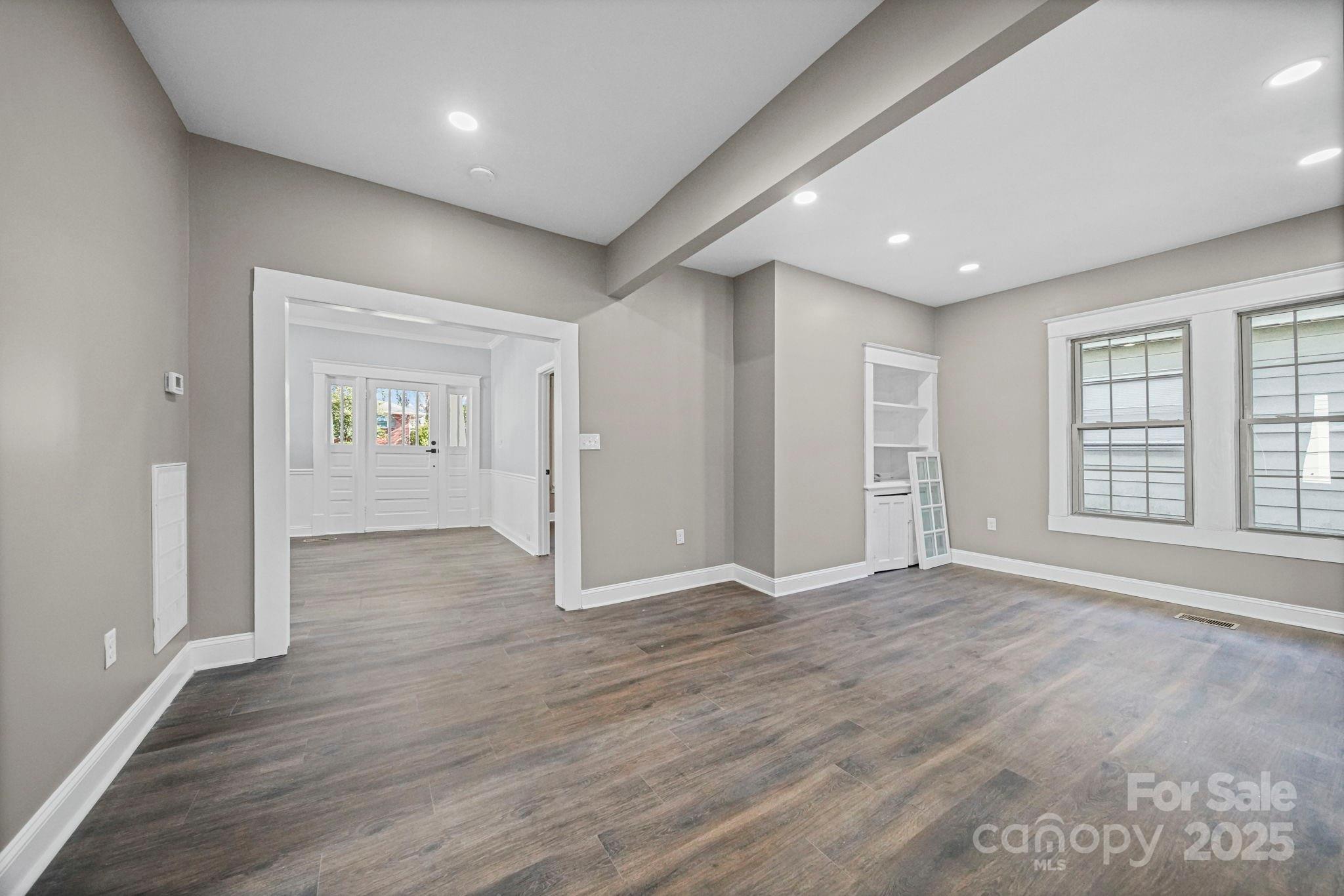 113 7th Street Spencer, NC 28159 - Photo 10 of 44 a view of an empty room with wooden floor and a window