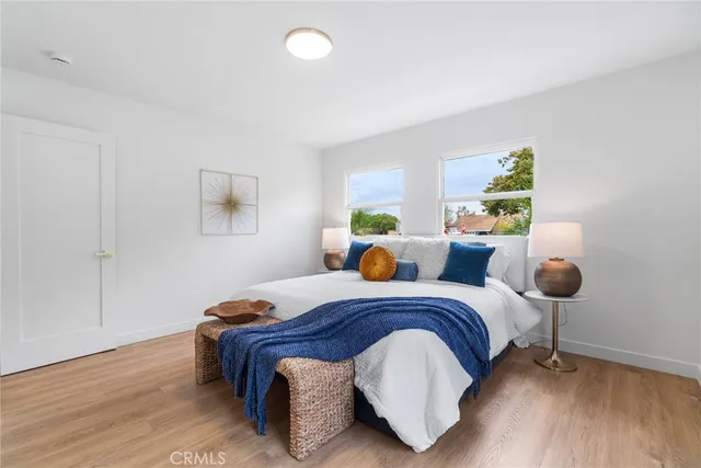 a bedroom with a bed and wooden floor