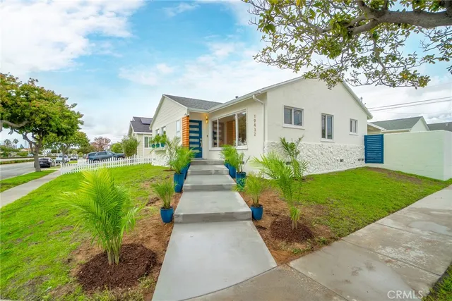 a view of a house with a yard and potted plants