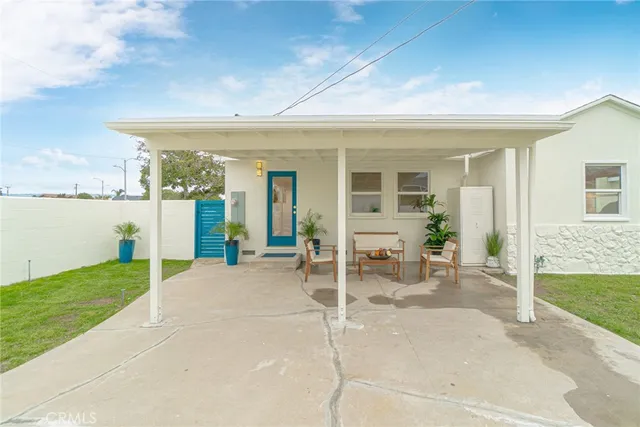 a porch with a table and chairs and potted plants