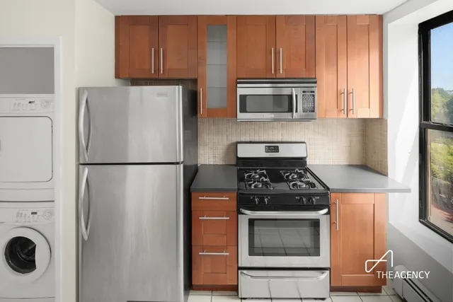 a kitchen with stainless steel appliances a refrigerator a stove a microwave a sink and cabinets