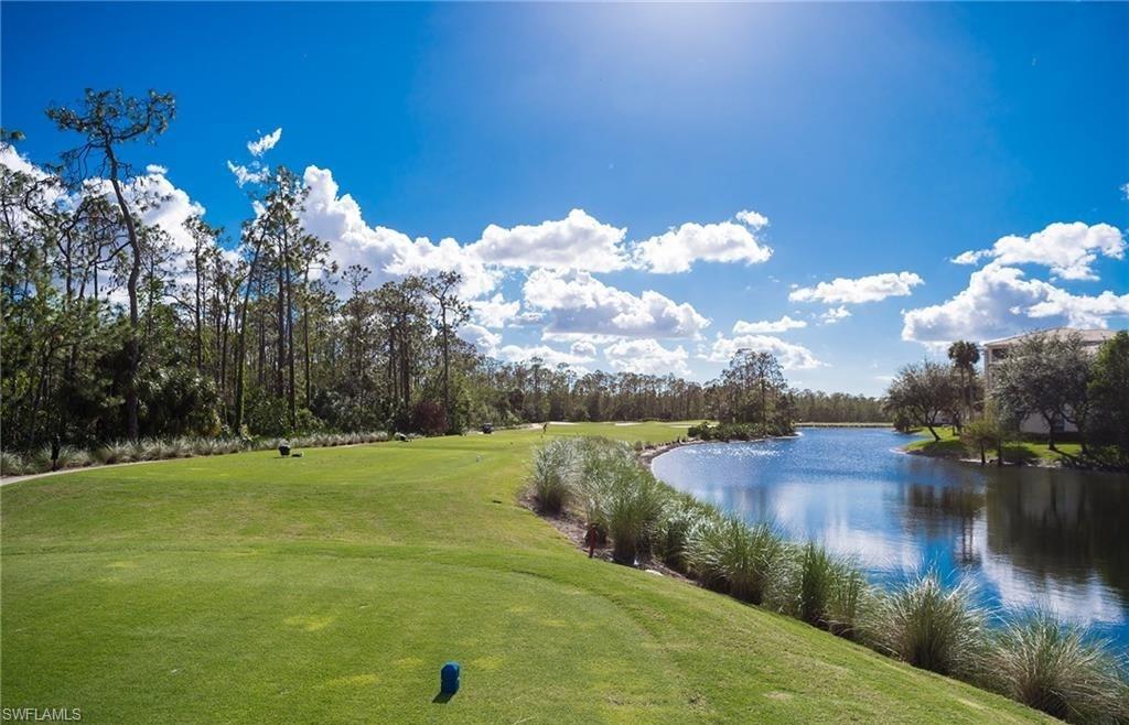 3830 Sawgrass Way, Unit 2934 Naples, FL 34112 - Photo 3 of 16 a view of a lake with a yard