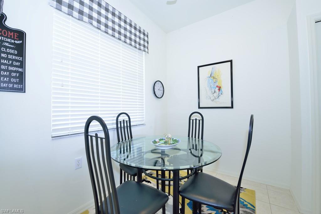 3830 Sawgrass Way, Unit 2934 Naples, FL 34112 - Photo 7 of 16 a view of a dining room with furniture and window