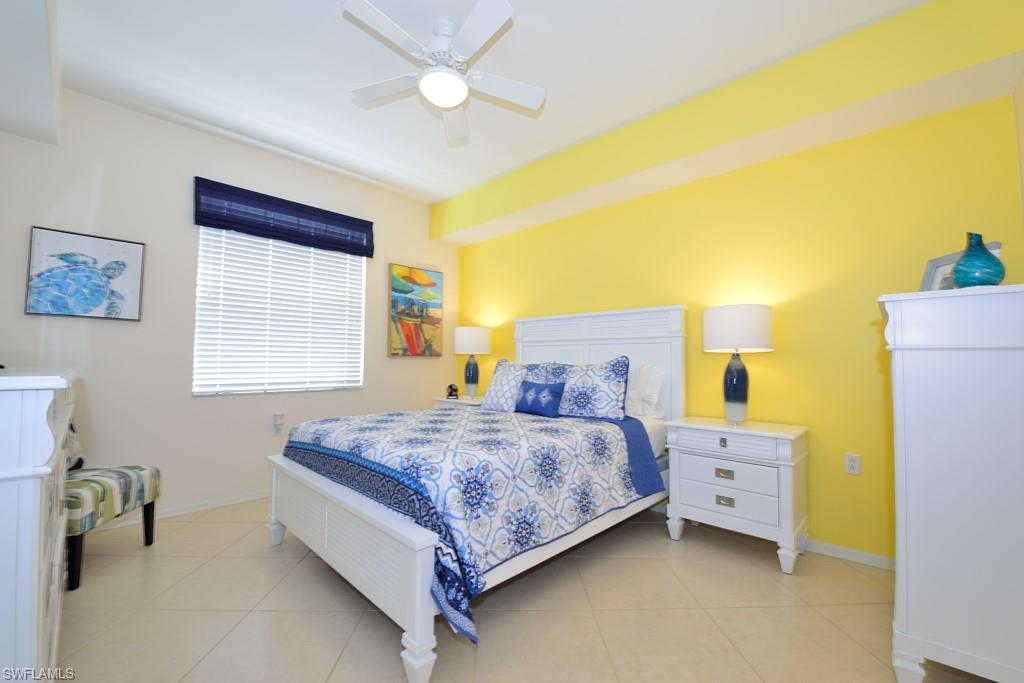 3830 Sawgrass Way, Unit 2934 Naples, FL 34112 - Photo 8 of 16 a bedroom with a bed and a chandelier